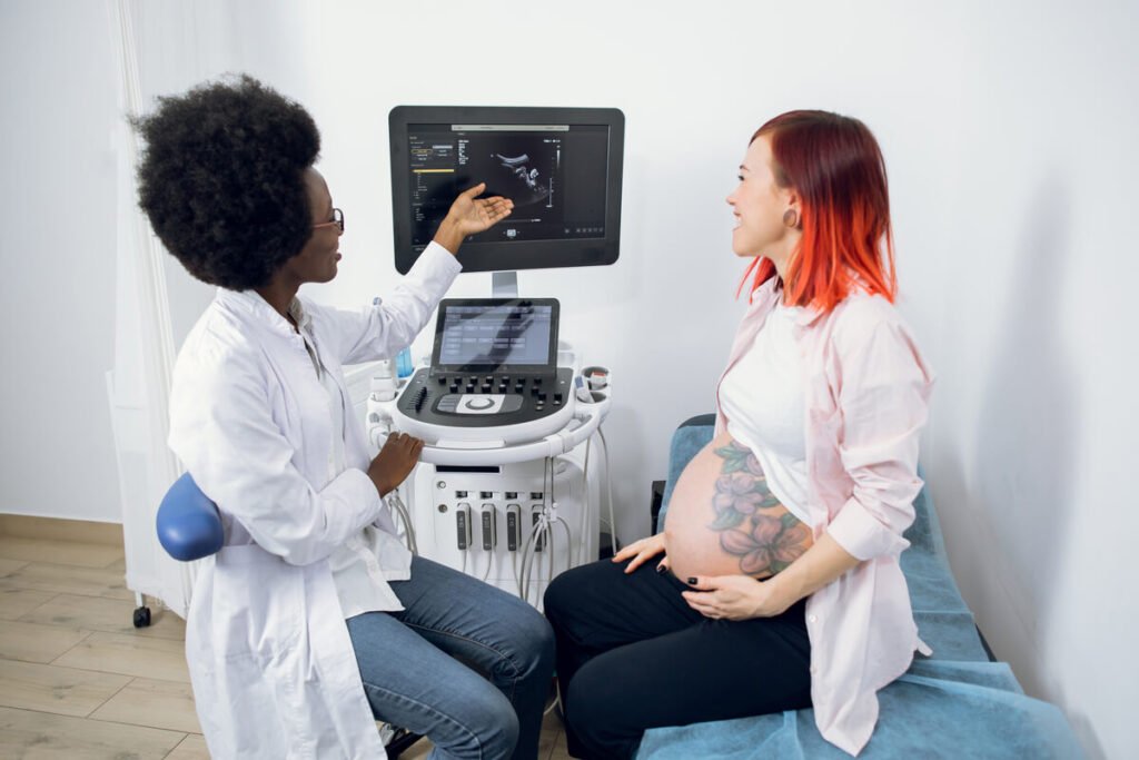 Activité cardiaque de l'embryon tardive : quand s'inquiéter et quelle conduite adopter ? 2 Médecin obstétricien expliquant les résultats d'une échographie de contrôle à une future maman.