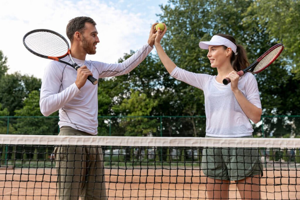 Deux joueurs de tennis épuisés se serrant la main au filet après une très longue rencontre