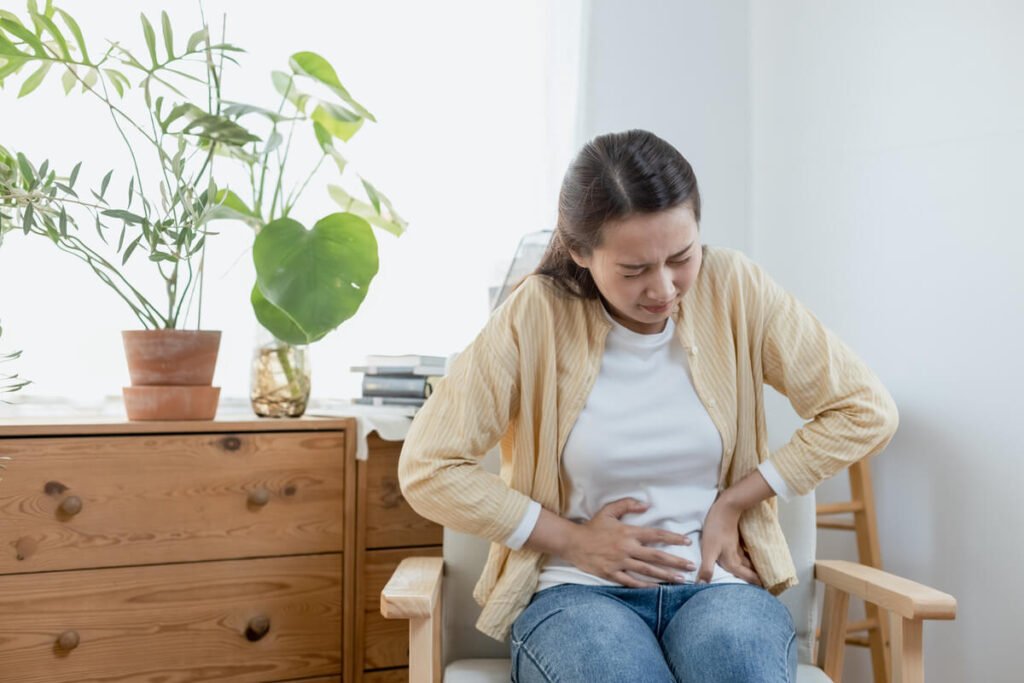 Peut-on mourir de la vésicule biliaire ? 2 Femme présentant une douleur sous les côtes droites, signe d'alerte d'une complication de la vésicule biliaire nécessitant une consultation urgente