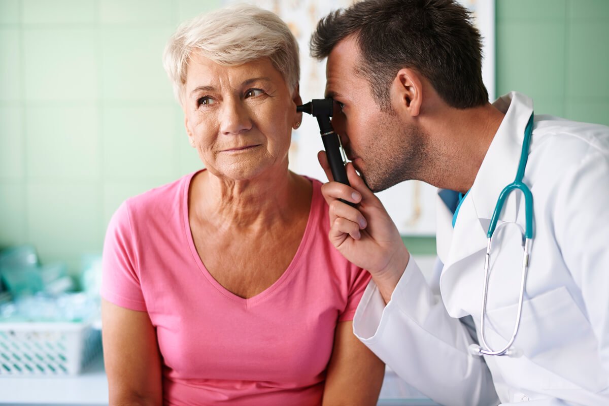 Un médecin ORL examinant le conduit auditif d'un patient à l'aide d'un otoscope de haute précision.