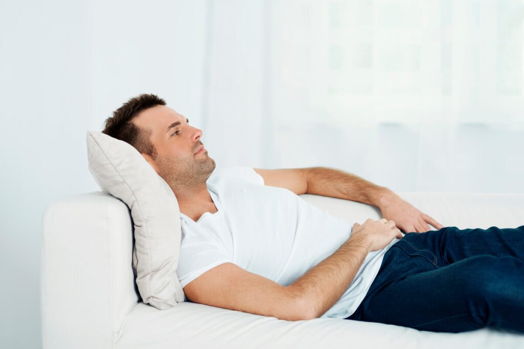 Un homme assis confortablement sur un coussin ergonomique pour soulager les douleurs pelviennes de la prostatite.