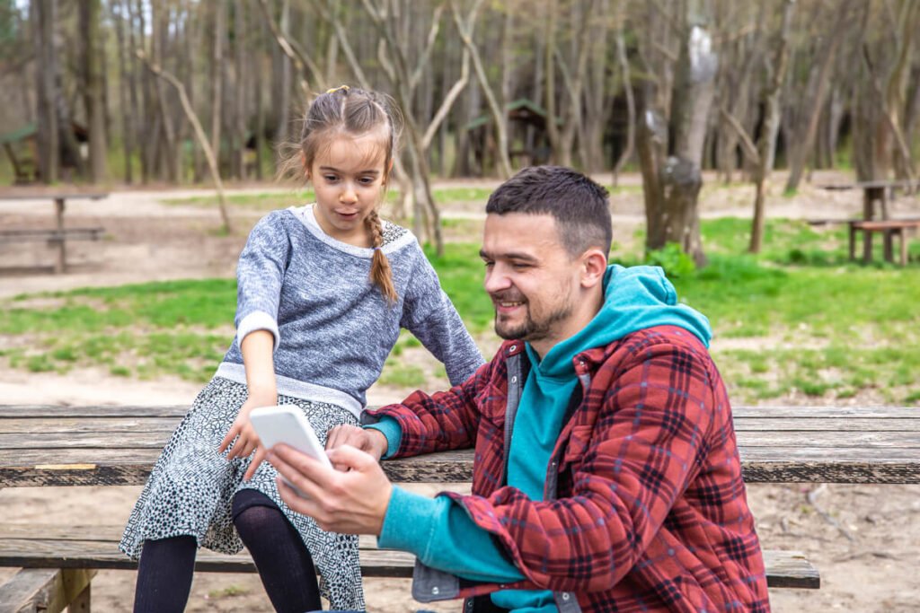 Un père et son fils discourant calmement installés sur un banc à l'extérieur.