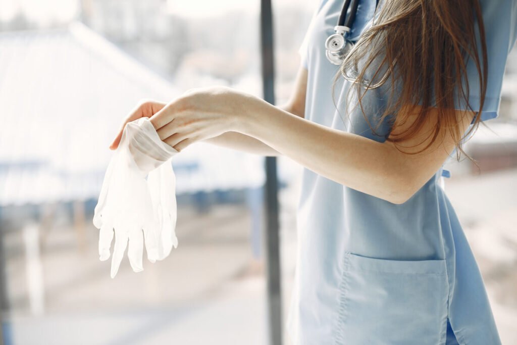Une infirmière préparant du matériel stérile pour refaire un pansement de soin dans une chambre.