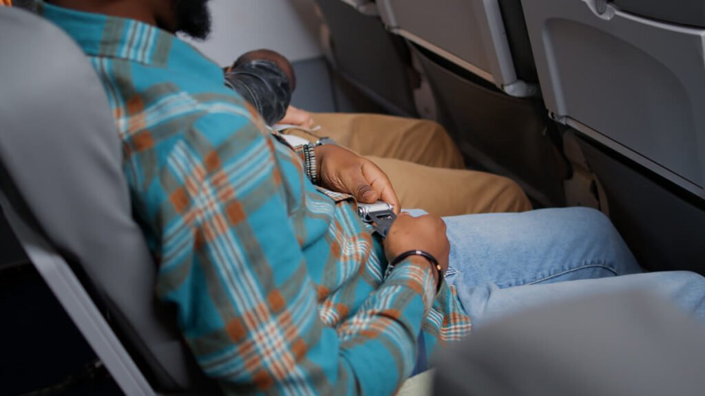 Porter une couche pour voyager : conseils pratiques et discrets 3 Un passager confortablement installé à bord d'un avion pour un long vol.