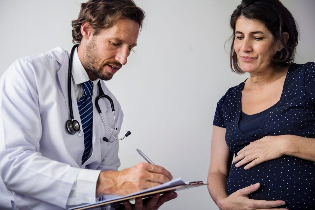 DPNI positif et amniocentèse négative : pourquoi ce résultat est fiable 2 Médecin obstétricien expliquant les résultats du caryotype foetal à un couple lors d'une consultation.