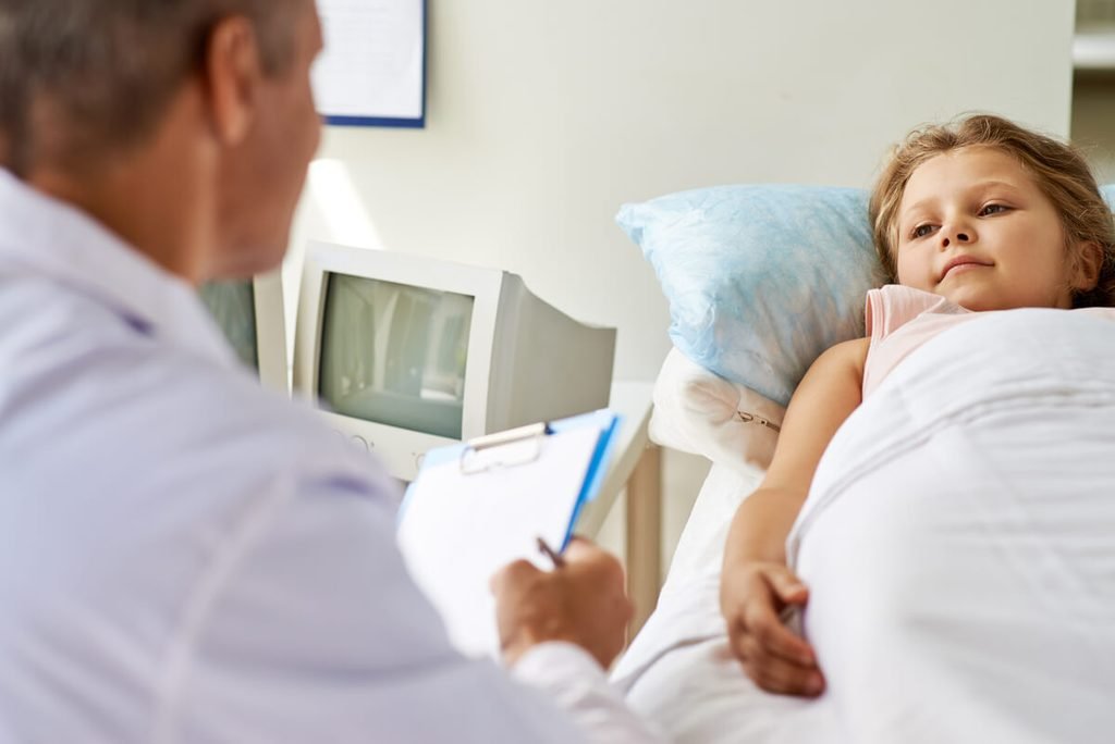Pédiatre discutant avec un enfant et ses parents pour traiter le pipi au lit.