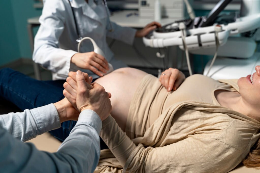 Sage-femme réalisant un contrôle du col et un monitoring en fin de grossesse.