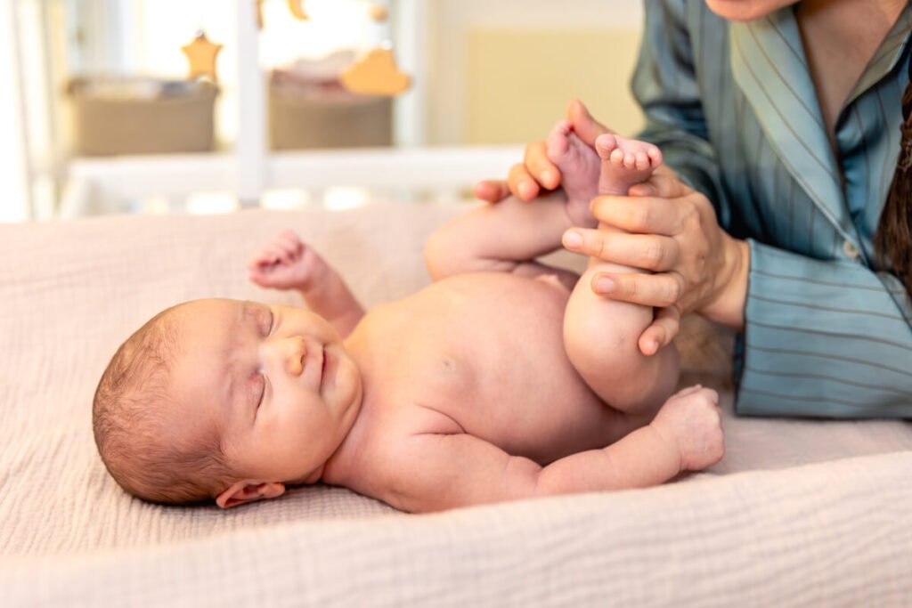Mère massant doucement le ventre de son bébé dans le sens des aiguilles d'une montre.