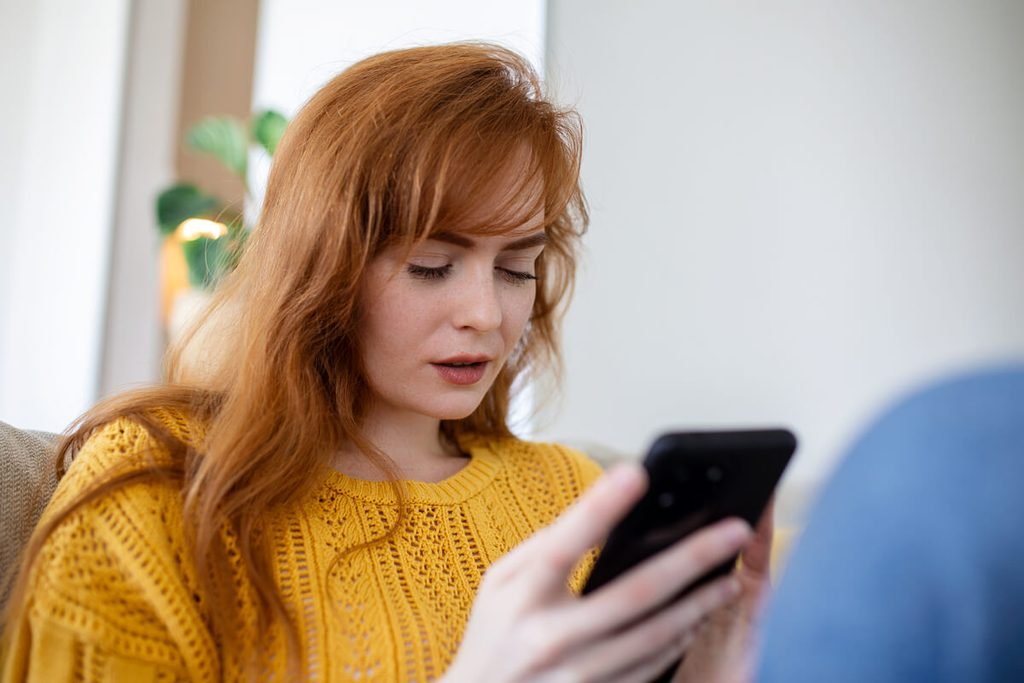 Bipolaire qui ne donne plus de nouvelles : comprendre et réagir 4 Proche inquiet regardant son téléphone sans réponse et cherchant comment aider une personne bipolaire.