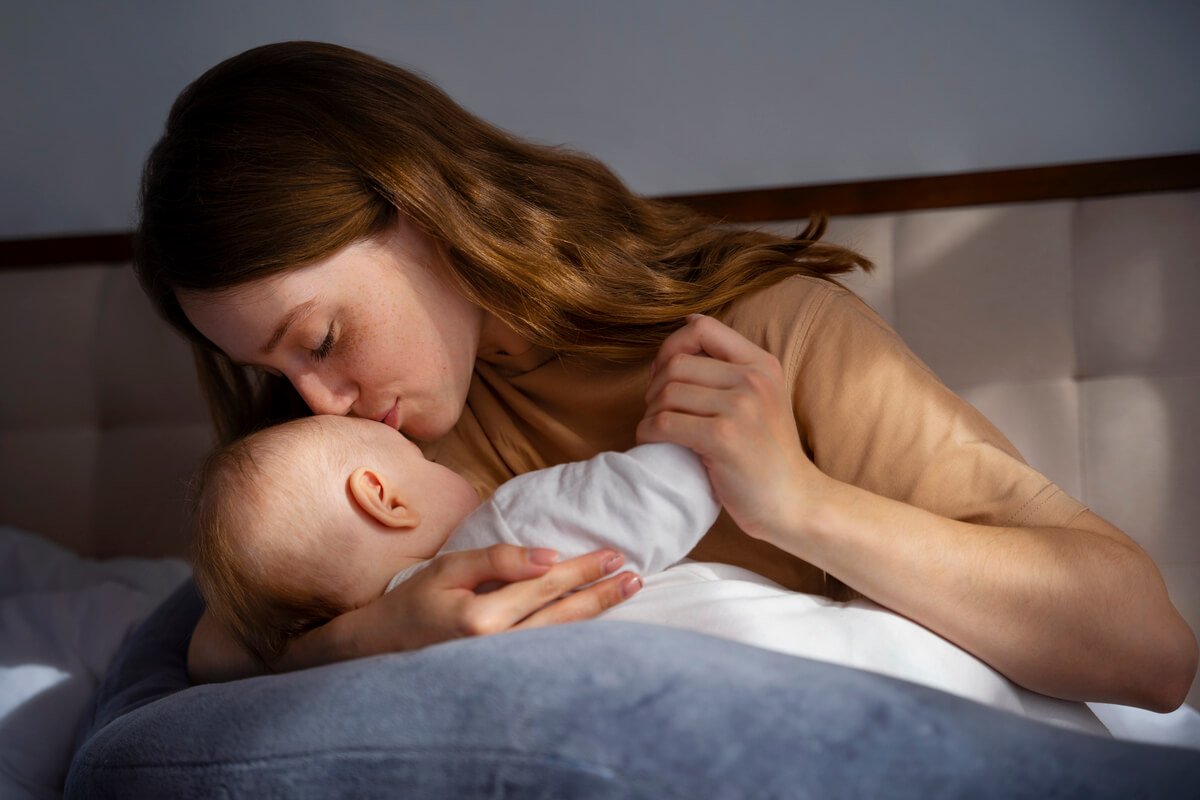 Bébé de quatre mois réveillé la nuit demandant le sein dans les bras de sa mère.