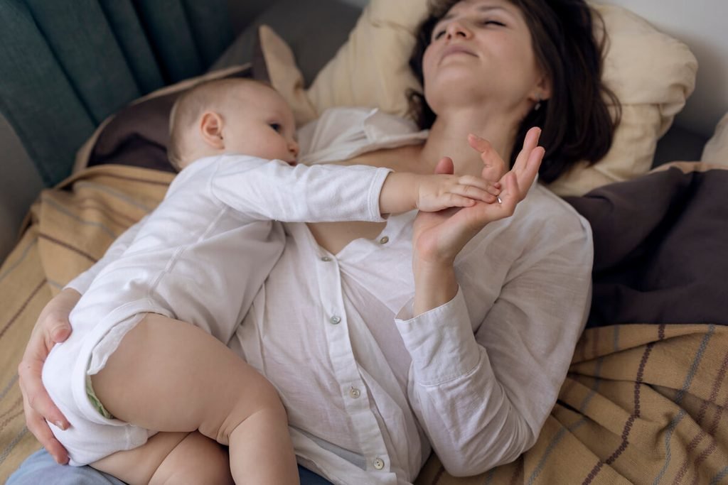 Au bout de combien de temps fait effet l'Inexium chez le bébé ? 3 Nourrisson enfin apaisé dormant paisiblement dans les bras de sa mère après le soulagement de son reflux.