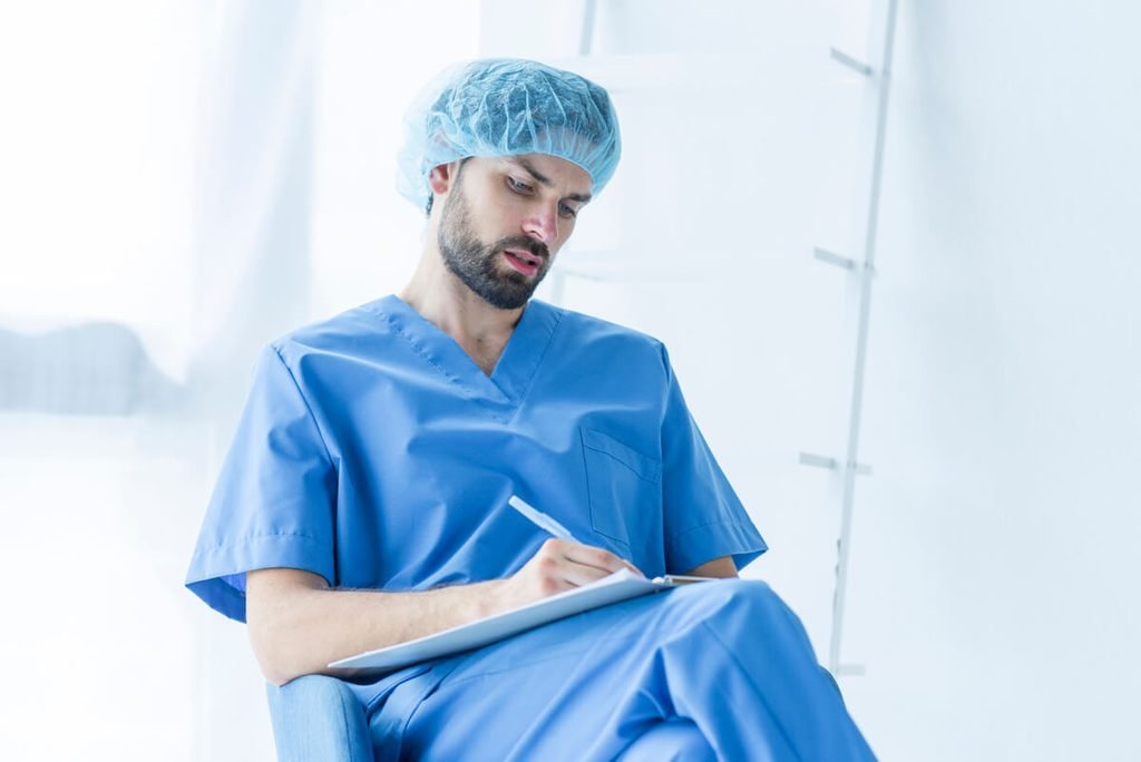 Combien de temps entre deux anesthésies générales 3 Médecin anesthésiste examinant les antécédents médicaux d'un patient lors d'une consultation pré-opératoire.