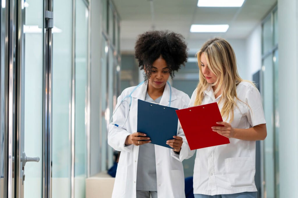 Être payé pendant ses études d'infirmière : est-ce possible ? 2 Étudiante infirmière en tenue de stage hospitalier consultant son planning de formation rémunérée.