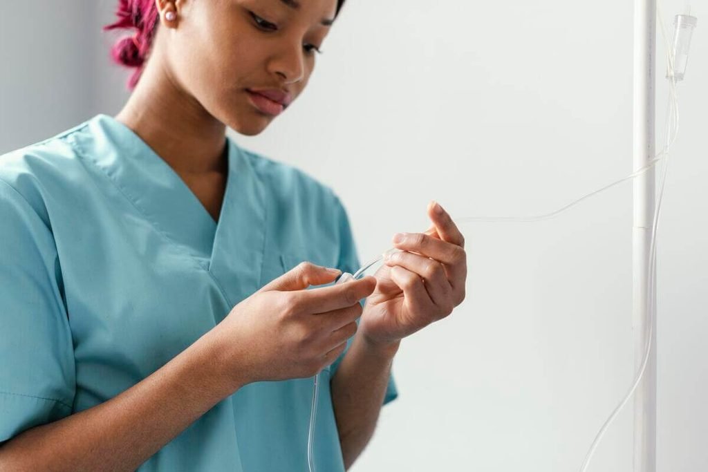Dial-A-Flow : régulateur de débit pour perfusion, utilisation et limites 3 Infirmière calibrant manuellement le débit d'une perfusion intraveineuse sur un patient perfusé.