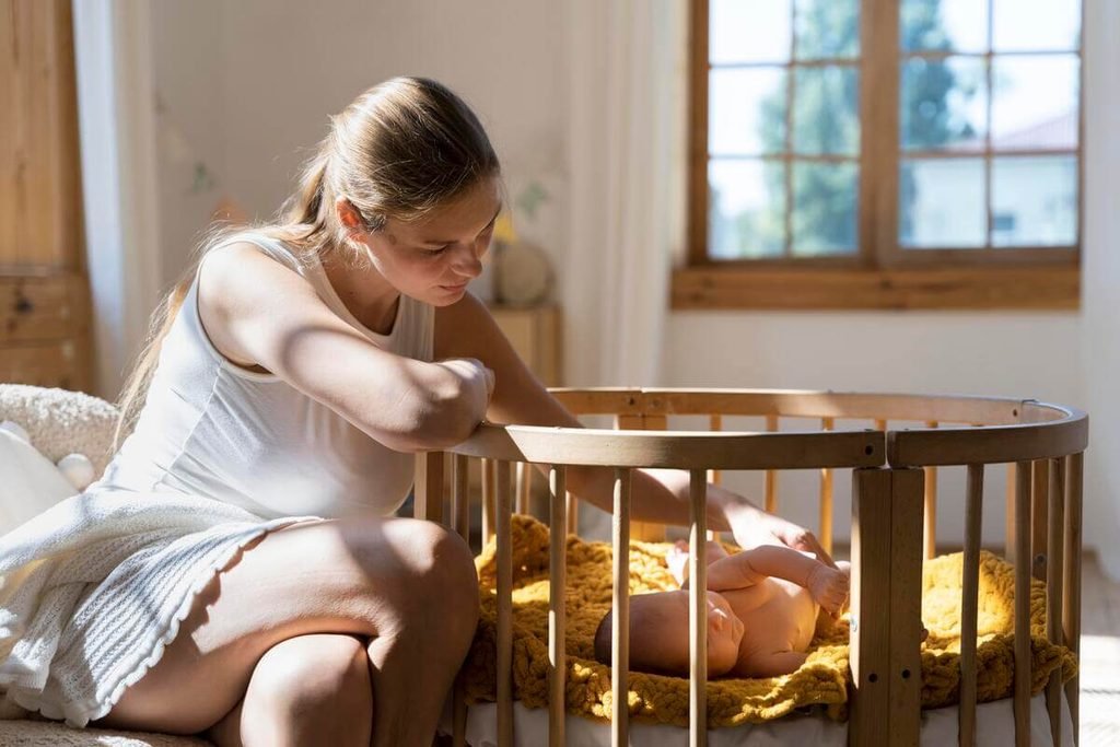 Mon bébé de 1 mois ne dort que sur moi : explications et solutions pour souffler 3 Berceau cododo fixé au lit parental pour favoriser la transition du sommeil sans réveil.