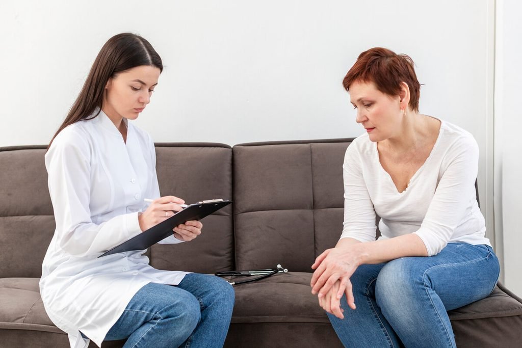 Médecin psychiatre discutant d'un traitement adapté et rédigeant une ordonnance pour un suivi de santé mentale.