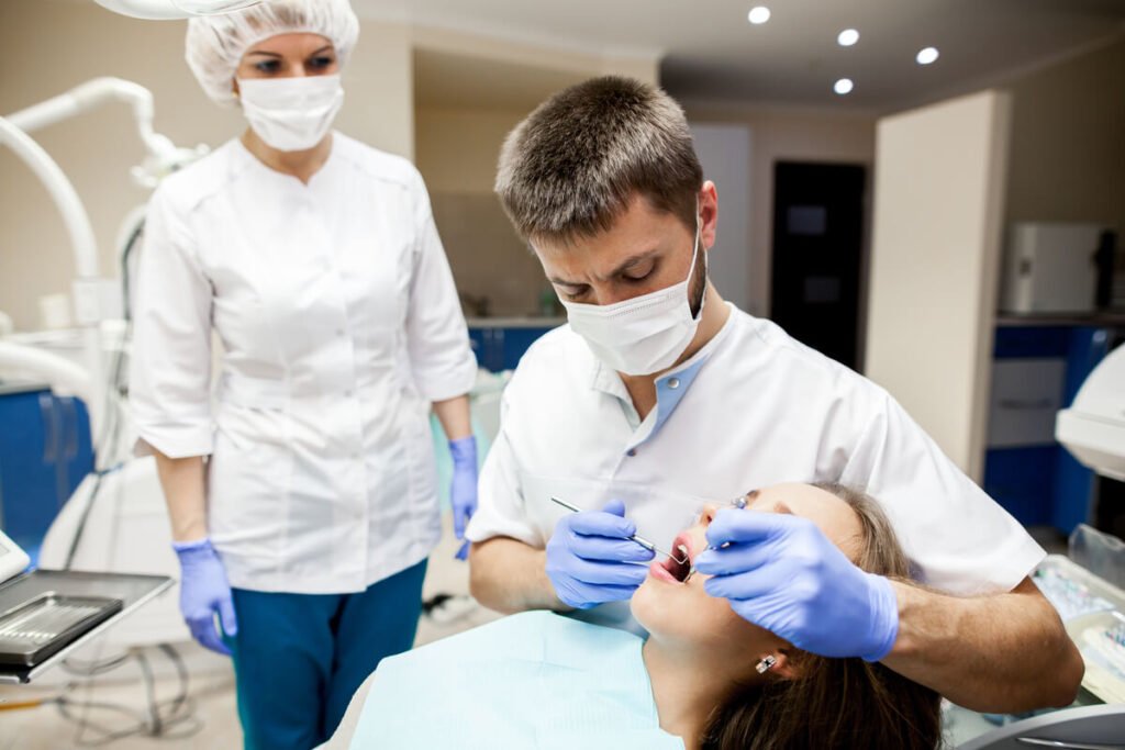 Chirurgien-dentiste examinant la gencive et le scellement d'une couronne douloureuse avec une sonde.