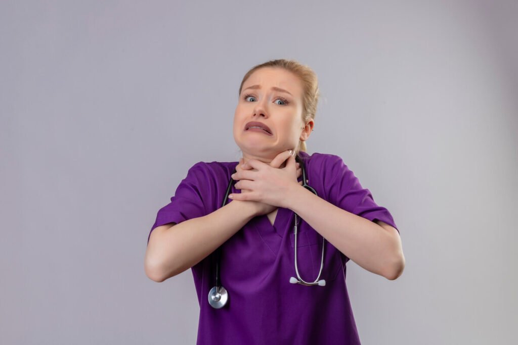 Reflux laryngo-pharyngé : témoignages, symptômes atypiques et guérison du RLP 2 Personne portant la main à son cou en raison d'une gêne permanente et d'une boule dans la gorge.