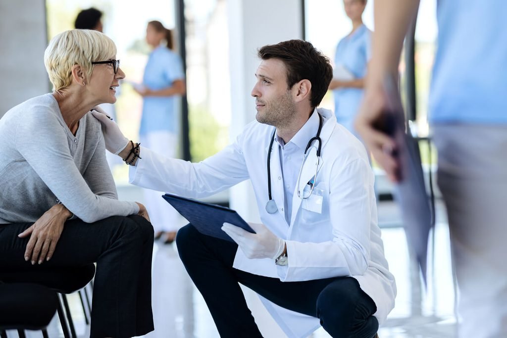 Médecin généraliste écoutant son patient pour l'orienter vers un spécialiste de la santé mentale.
