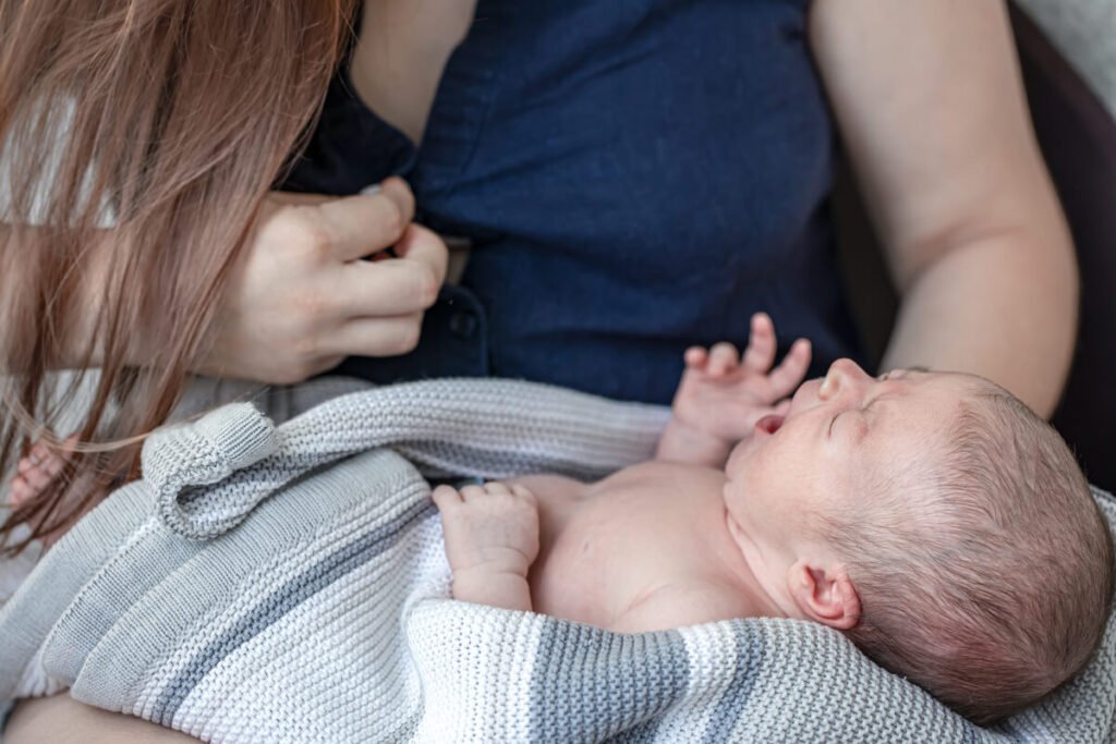 Mon bébé de 1 mois ne dort que sur moi : explications et solutions pour souffler 2 Nourrisson de 1 mois endormi en toute sérénité sur le thorax de sa maman en écharpe de portage.